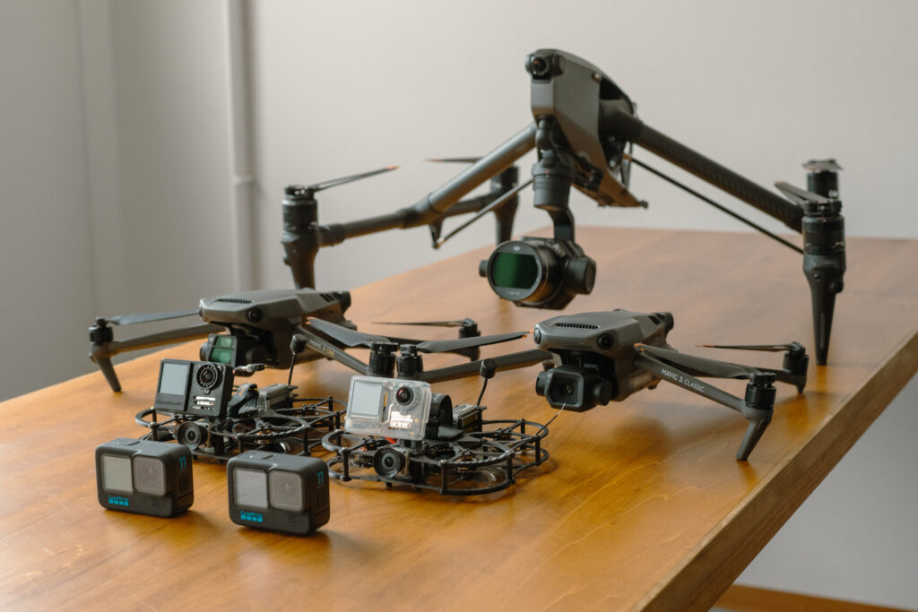 DJI INSPIRE 3やMavic、GoPro搭載型ドローンなど複数の機体を机上に並べた構成機材の紹介写真